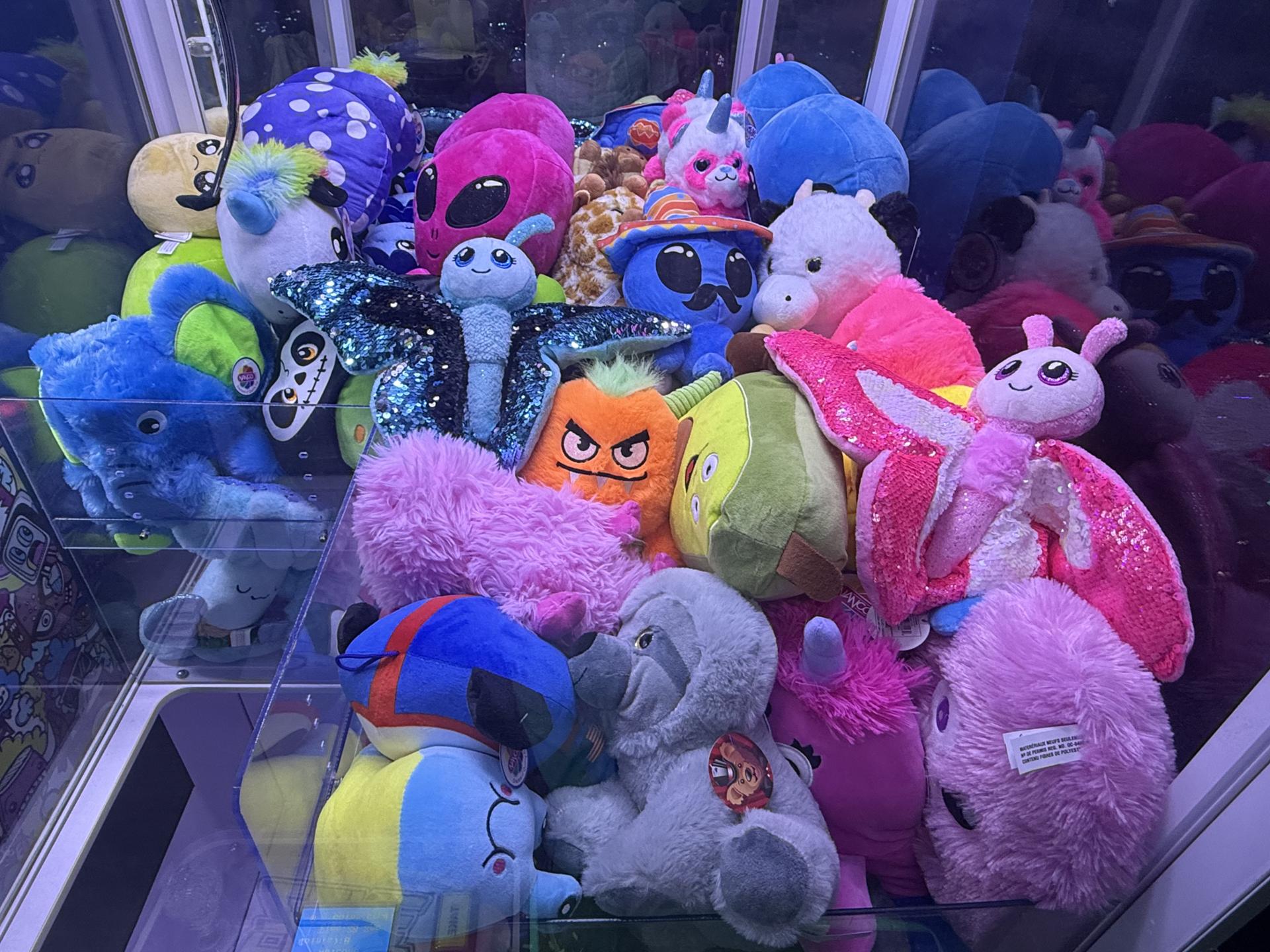 Large claw machine with plush inventory in a bar arcade zone